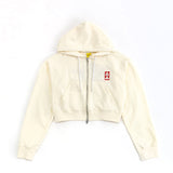 Beige hoodie with a small red logo on a white background