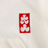 Embroidered red and white design on a beige fabric background
