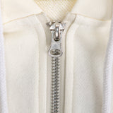 Close-up of a silver zipper on a white garment